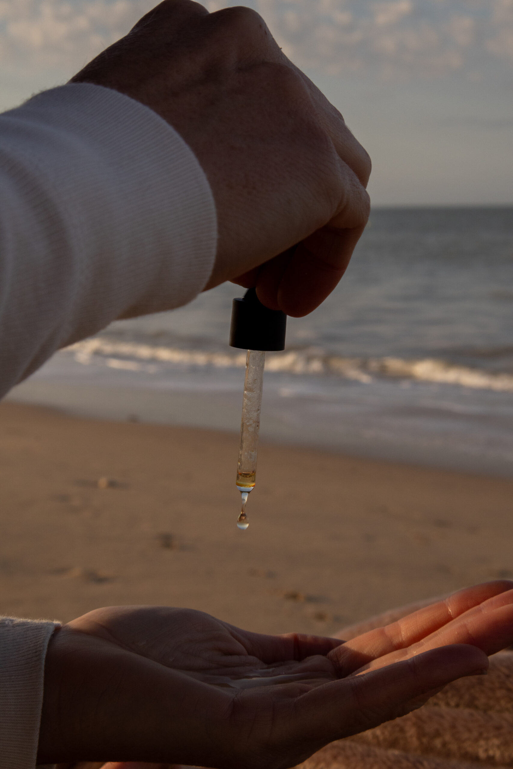 person holding amber glass bottle